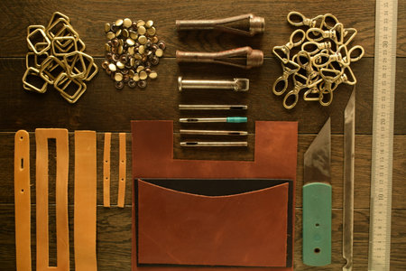 Leather workshop, handbag manufacturing industry, hand craft. Numerous metal elements bag hardware...