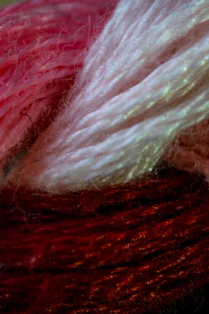 Pale pink, purple and red sewing threads pattern macroの写真素材