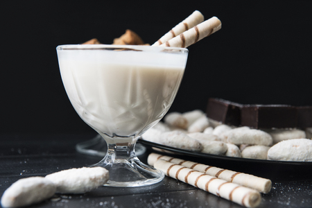 sweets, straws in the cream, cookies and candies on the tableの写真素材