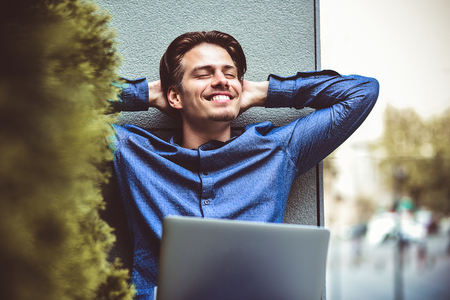 Happy freelancer make his job well and relaxed at street.の写真素材