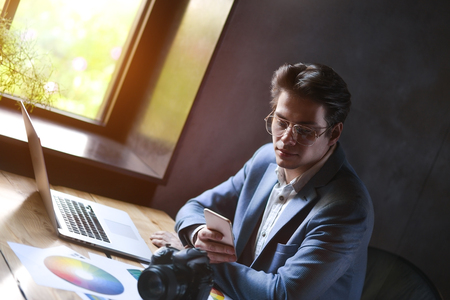 Business, startup and people concept - happy businessman or creative male office worker with computer calling on smartphoneの写真素材