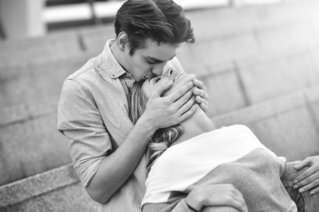 Happy to spending time together. Young beautiful couple outdoor fashion portrait. Attractive couple hugging and boy kissing a girl.の写真素材