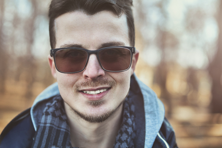 Young stylish and confident happy handsome guy model in sunglasses lifestyle in the parkの写真素材