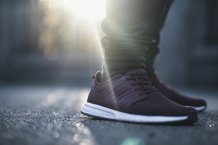 Man in sneakers walks down the street on a sunny dayの写真素材