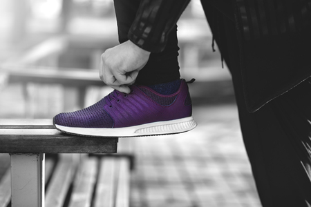 Man in sneakers walks down the street on a sunny dayの写真素材