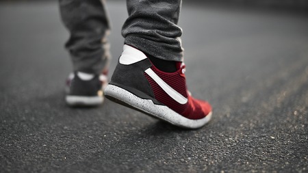 Man in sneakers walks down the street on a sunny day