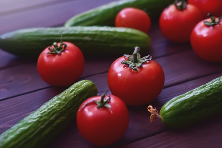 Nature Gifts. Benefits for the body. Fresh sliced vegetables lie on a wooden table. Tomatoes .cucumbersの写真素材