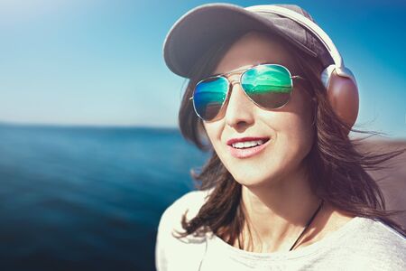 Happy joyful woman listening to music while being outdoor. Music concept.の写真素材