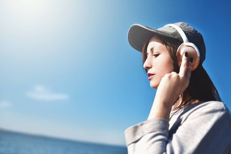 Happy joyful woman listening to music while being outdoor. Music concept.