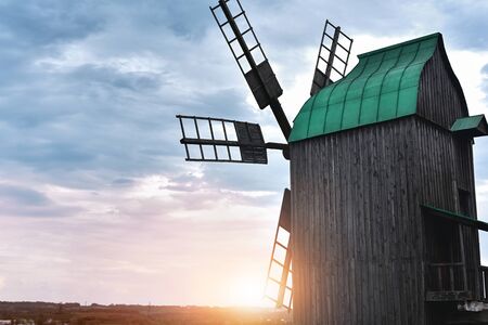 Old windmill standing alone in the field with the blue sky on the background with copyspaceの写真素材