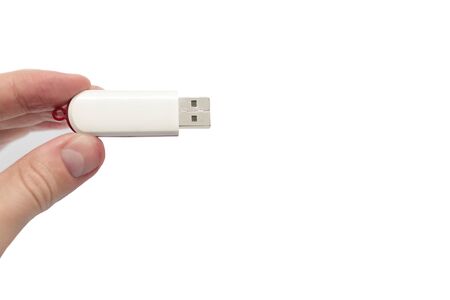 USB flash drive close up shot held between fingers by Caucasian male hand isolated against white...