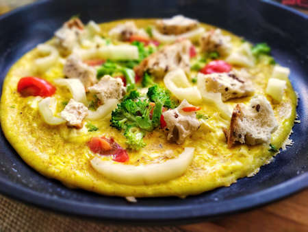 omelet with vegetables and crunches in a frying panの写真素材