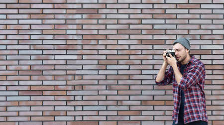 Say cheese, hipster fashion photographer man holding retro camera. panoramic view. copy space