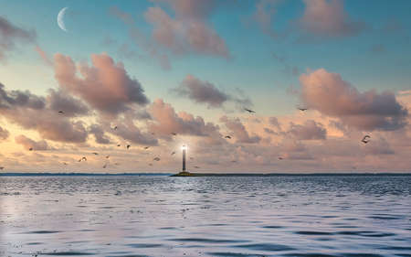 White lighthouse against the calm sea, cloudless evening sky. Seascape of Black sea.の写真素材