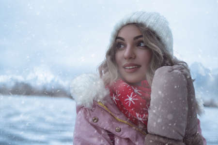 The charming woman walks among the winter mountains at ski resort. The ice in the frozen lake shifting and make amazing noises. The acoustics of the frozen lake creates a dreamy atmosphere.の写真素材