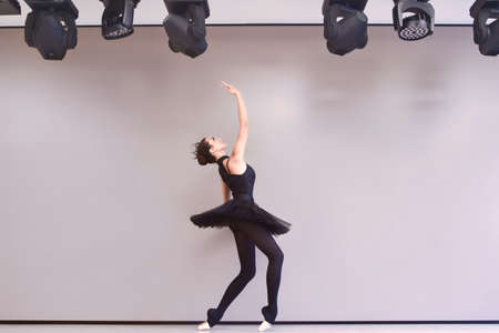 Young ballet dancer black swan practicing before performance in black tutu, classical dance studio, copy spaceの写真素材