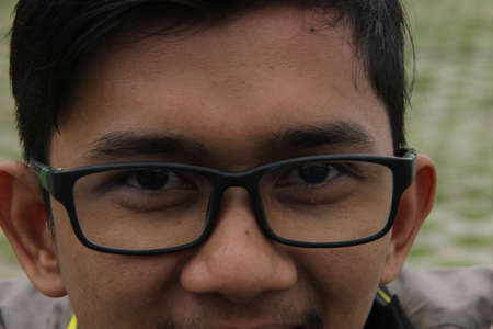 portrait of Asian man with glasses. human face skin texture