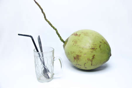 empty glass with green coconut isolated on white background. natural fresh drinkの写真素材