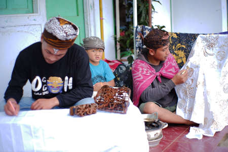 Pasuruan, Indonesia. June 2021. a child who is helping his parents to make batik. Written batik and stamped batik are typical of the Bromo Tengger tribe. portrait of ethnicity and culture in Indonesiaのeditorial素材