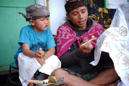 Pasuruan, Indonesia. June 2021. A father is teaching his son to make batik. portrait of the next generation to maintain ethnicity and culture in Indonesia. the typical batik of the Bromo Tengger tribeのeditorial素材