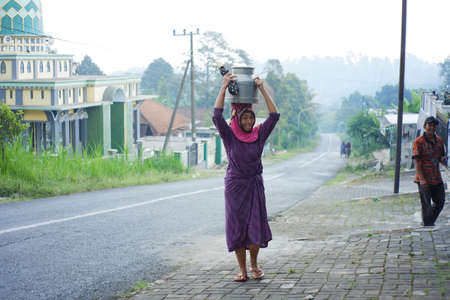 Pasuruan, Indonesia. august 2021. activities of residents and employees are sorting cow's milk in a dairy cow's milk distributor company. the tradition of the highlanders of dairy farmersのeditorial素材