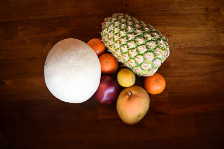 The tropical fruits and Odd Apple all together on a wooden tableの写真素材