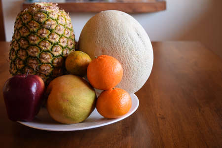 The tropical fruits and Odd Apple all together on a wooden tableの写真素材