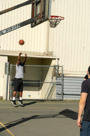 Seattle, Washington - 2019-03-17 - Man shooting ball at basketball hoop in Greenlake as Spring...