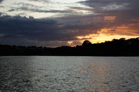 Niegocin lake Mazury Poland sunset on the lake with orange sky cloudy clouds red and purple sunの写真素材