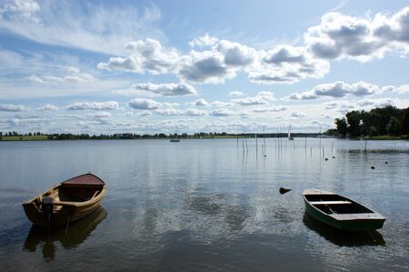two boats moored on the lake reflection of the clouds in the waterの写真素材