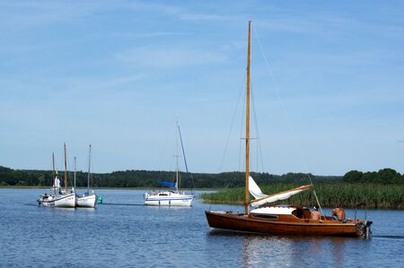 sailboat boat floats on the lake and blue sky sail folded sailsの写真素材