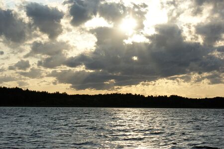 lake Mazury Poland sunset on the lake with orange sky cloudy clouds red and purple sun TaÅty lakeの写真素材
