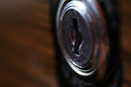 keyhole metal lock in wooden door dark brown woodの写真素材