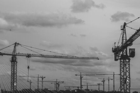 crane construction couple construction on the background of sky and cloudsの写真素材