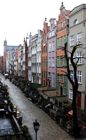 Old town square buildings lit by the sun in a row, in the market square Gdansk, Poland three...