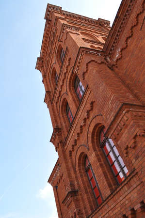 old red brick building with a tenement tower in the old town windows and blue sky