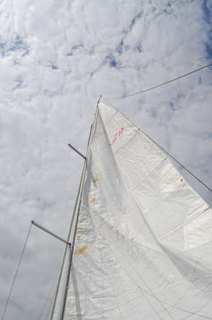 sail from a sailboat on a lake against the sky nautical ropes