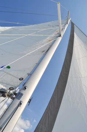 sail from a sailboat on a lake against the sky nautical ropes