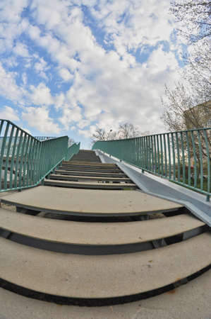 footsteps on the path on the bridge with green balustrade cloudy sky