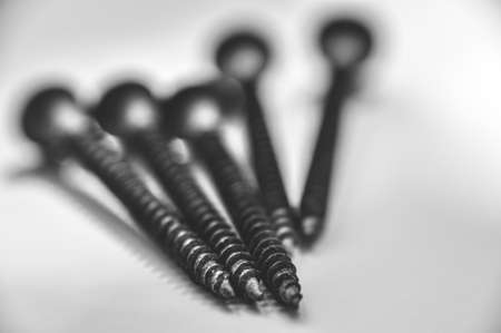 the five screws on the thread side lie on the white table top black and whiteの写真素材