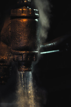Water condensing from steam on a steam train, locomotive in the darkness at night, dim lantern light