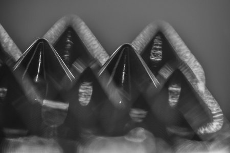 Close-up macro of sewing studs arranged in symmetrical rows in black and white abstraction