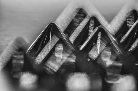 Close-up macro of sewing studs arranged in symmetrical rows in black and white abstraction