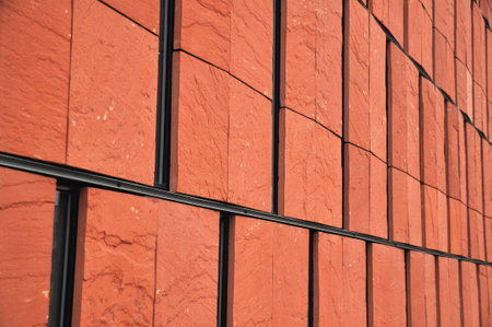 Red brick facade with narrow windows of a modern building, modern architecture