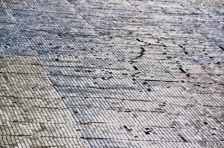 dingy building wall old facade shabby colorful mosaic sun reflection lightの写真素材