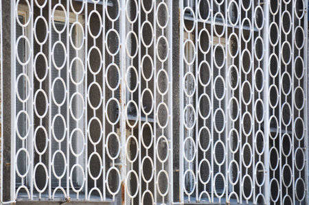 old rusty white fence with circular shapesの写真素材