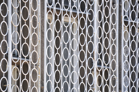 old rusty white fence with circular shapesの写真素材