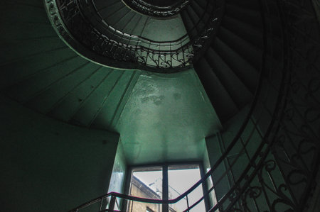 Green staircase with winding stairs, natural delicate light from windowの写真素材