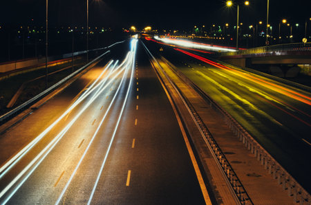 This captivating night photography utilizes a long exposure technique to transform moving vehicles...