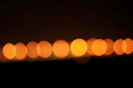 This striking night photograph captures the mesmerizing bokeh effect of city lights, transformed...